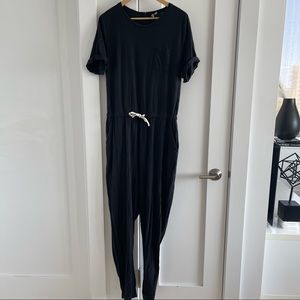 Long black cotton jumpsuit with rolled short sleeves and drawstring waist